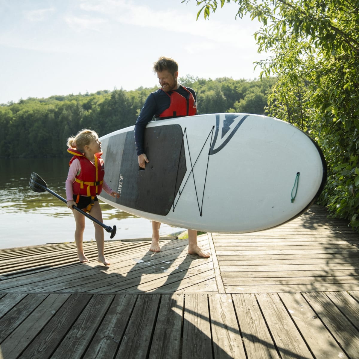 Father and daughter with a paddleboard.