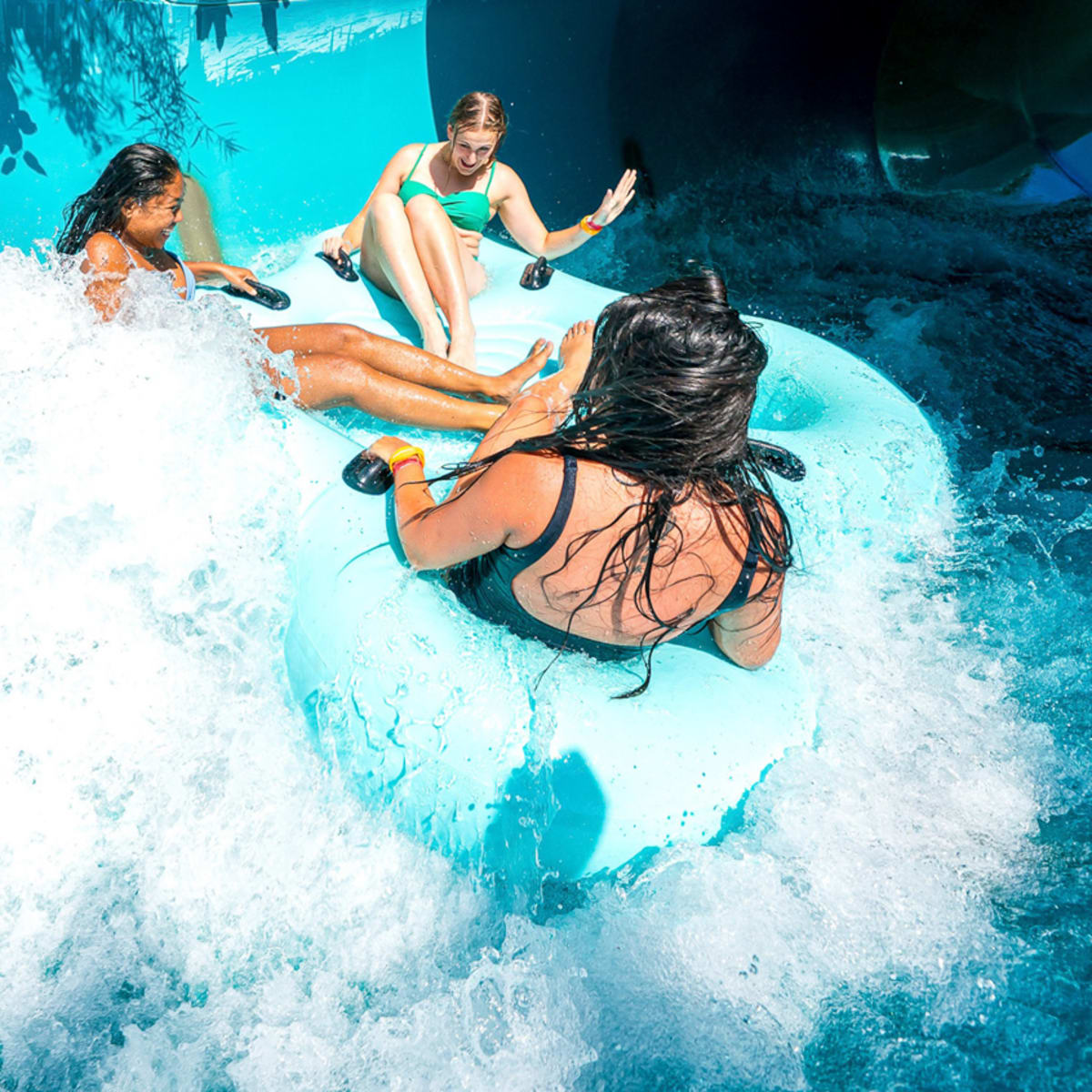Trois personnes dans une glissade d'eau sur tube