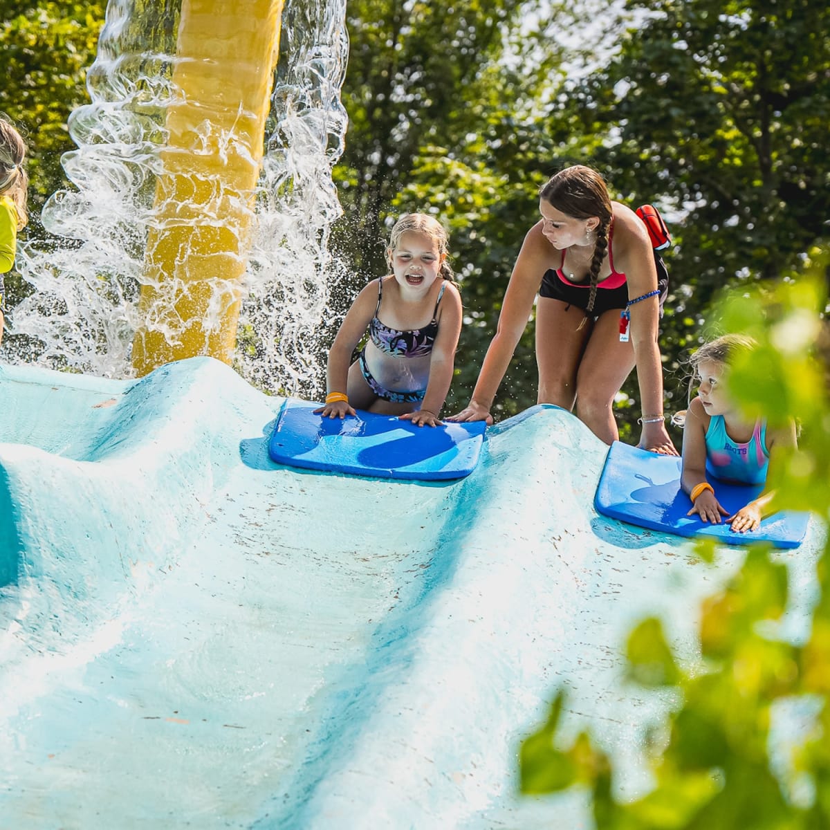 Deux jeunes enfants qui se lancent sur un tapis d'une glissade d'eau