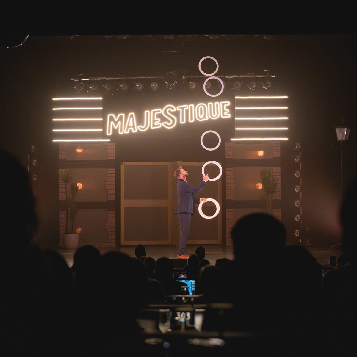 Théâtre Place Majestique un jongleur performe avec des petits cerceaux sur scène