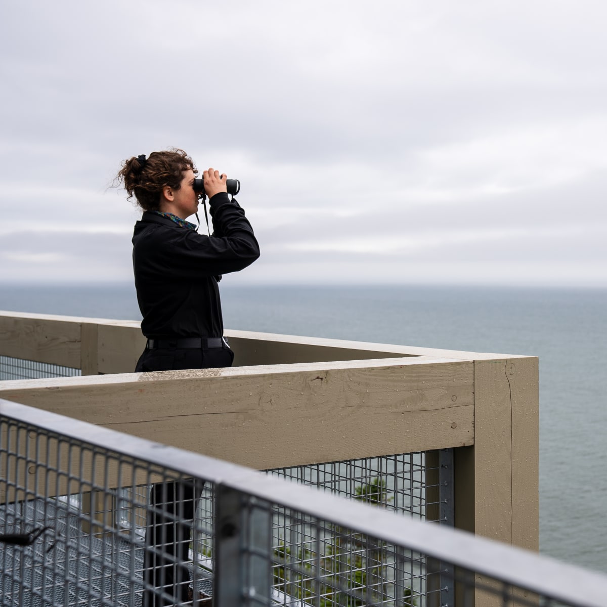 Femme qui observe les bélugas au Bas-Saint-Laurent.