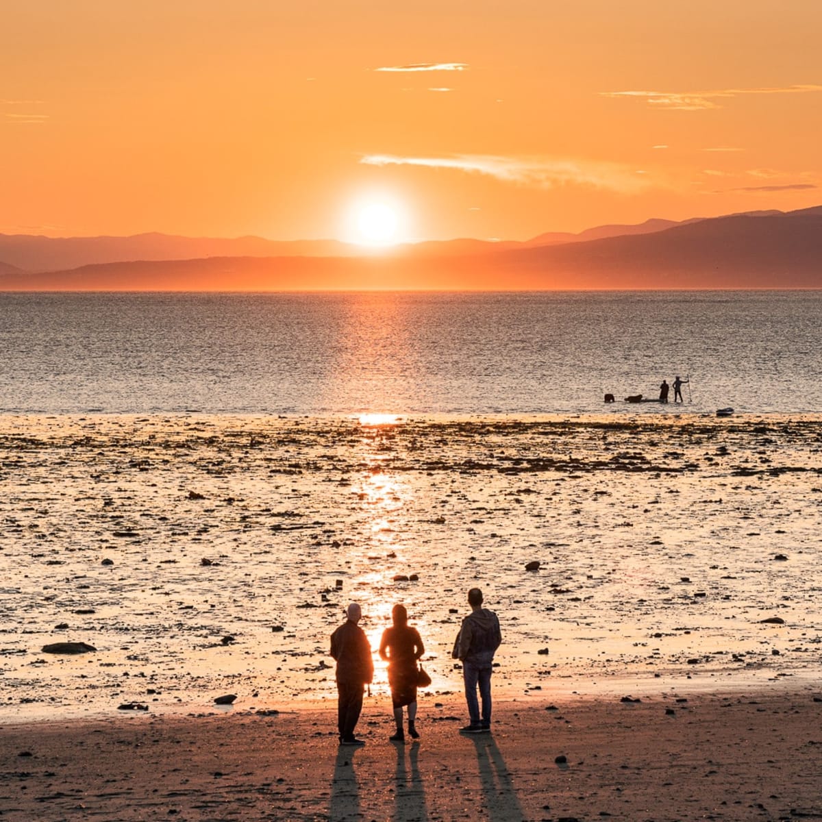 Gens regardant le coucher de soleil à Kamouraska. 
