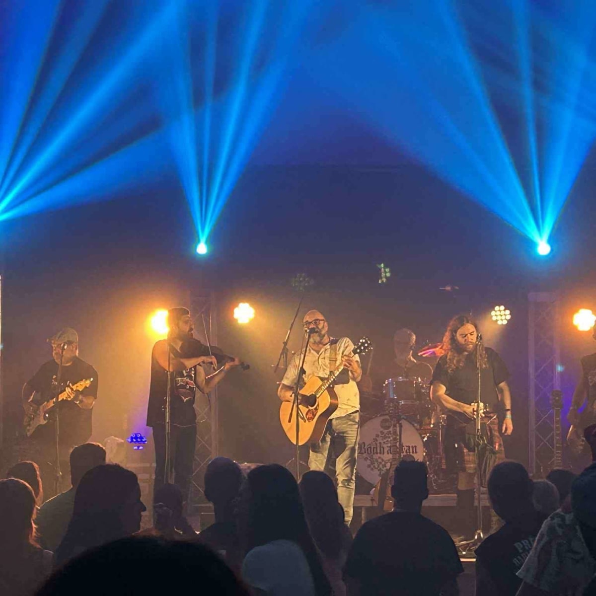 Groupe en train de performer sous les lumières bleutés lors du Festival du Fjord.