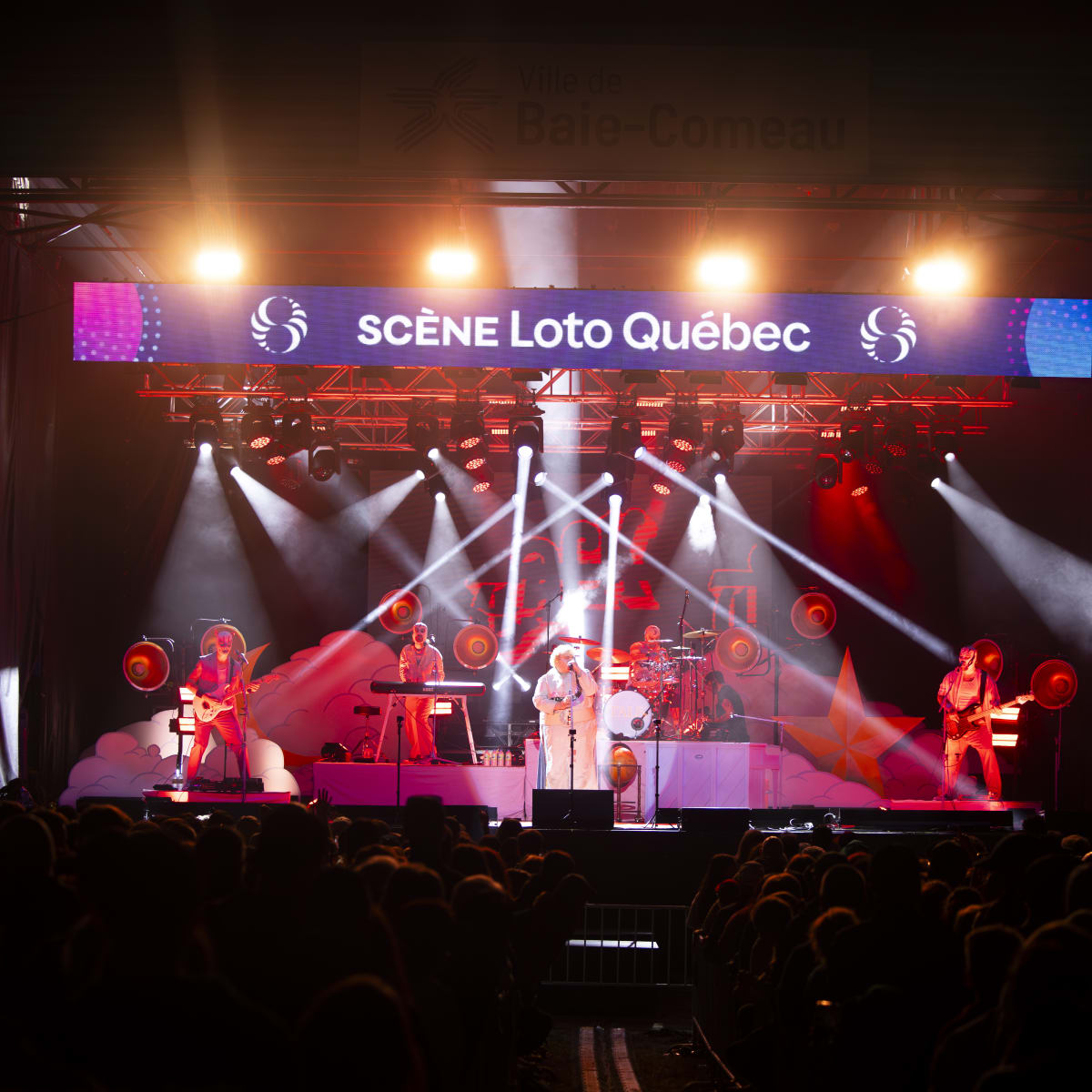 Scène illuminée du Festival Eau Grand Air en soirée.