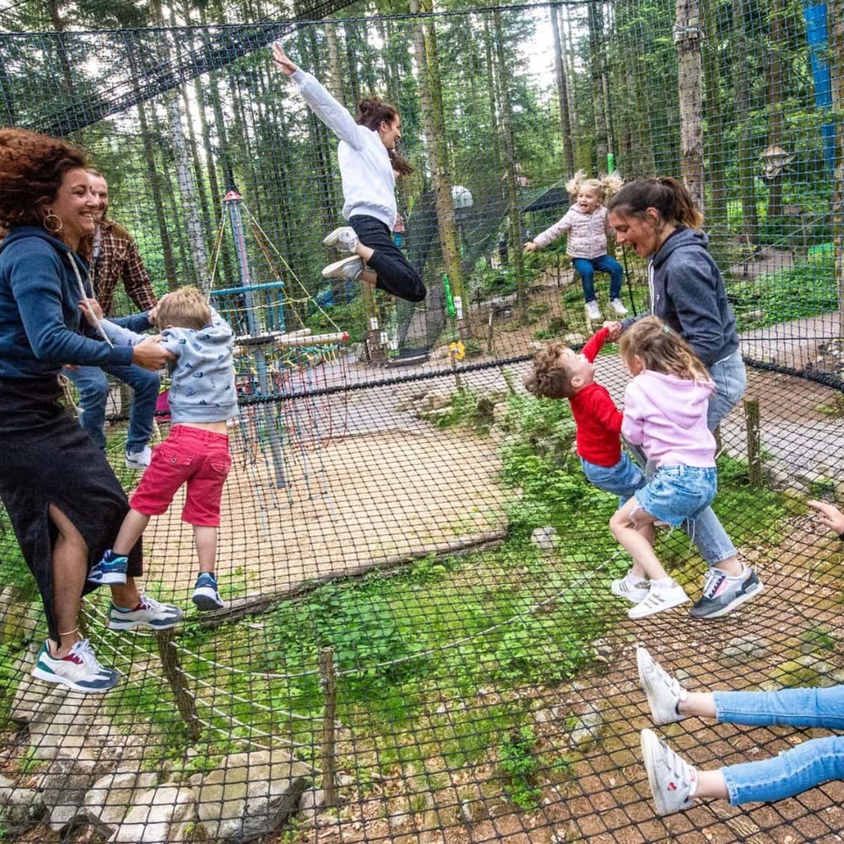 Famille et enfants s'amusant sur un filet trampoline, Bois des lutins.