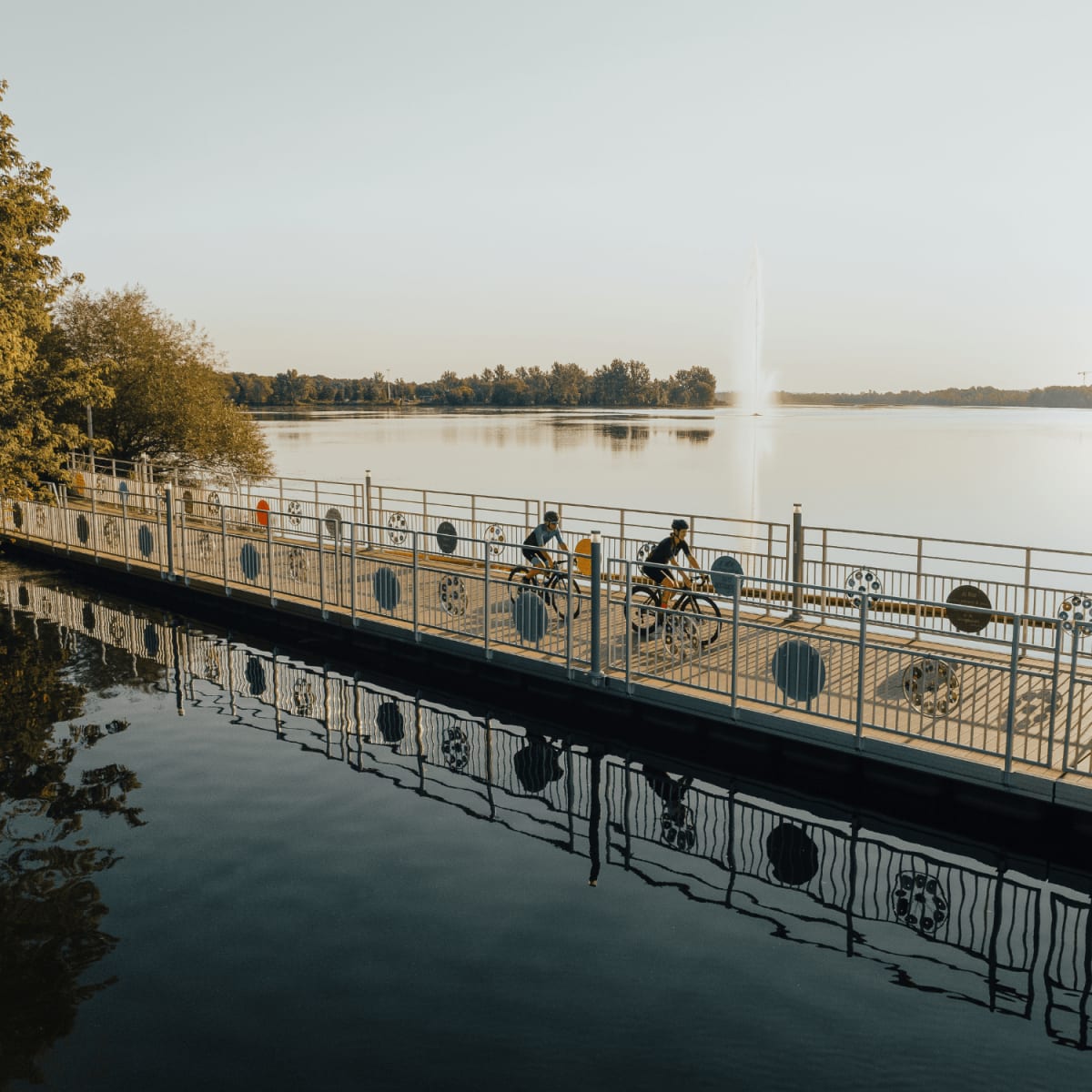 Deux cyclistes sur le pont flottant à Granby en été.