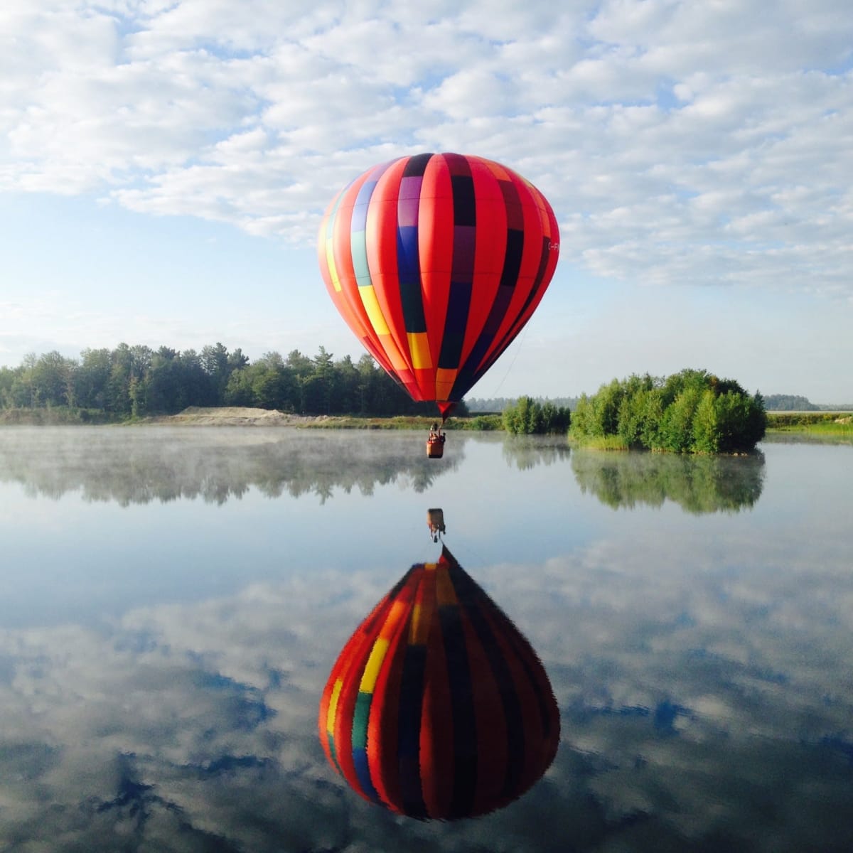 Montgolfière au-dessus d'un lac.