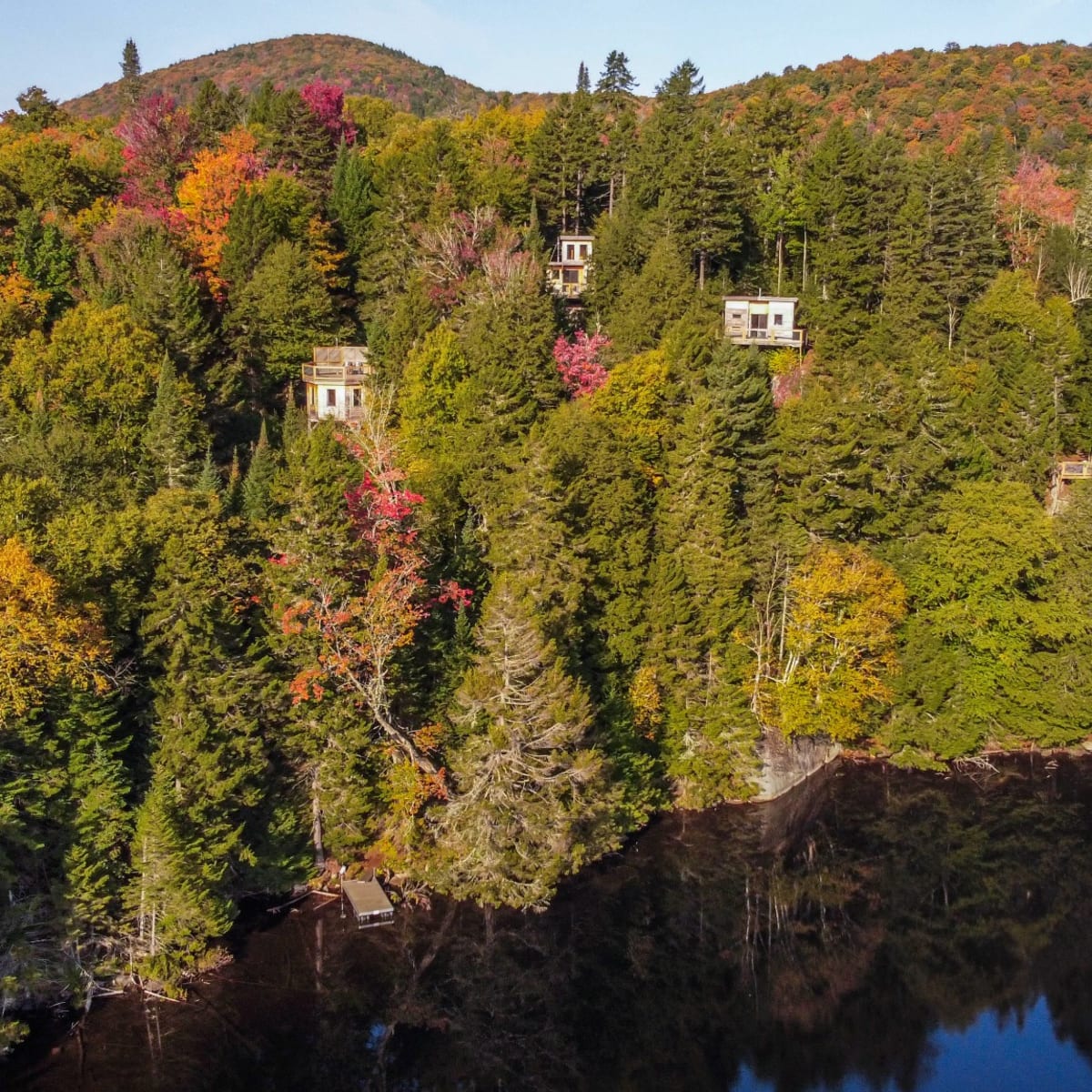 Les Refuges Perchés Mont-Tremblant : montagne colorée ponctuée de petits refuges.