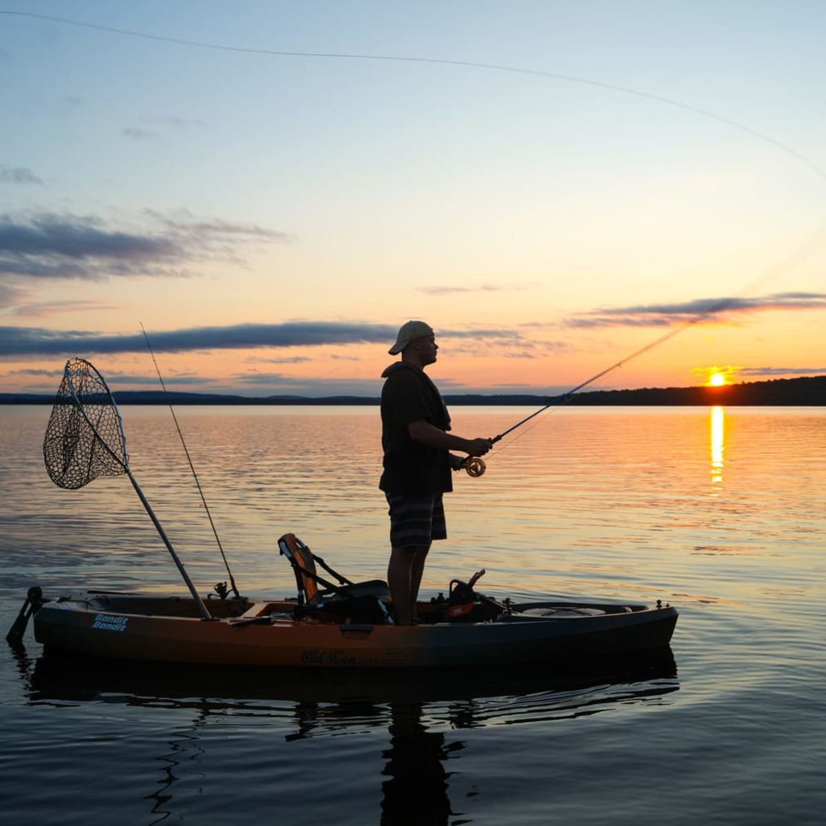 Pêche sur un lac au lever de soleil.