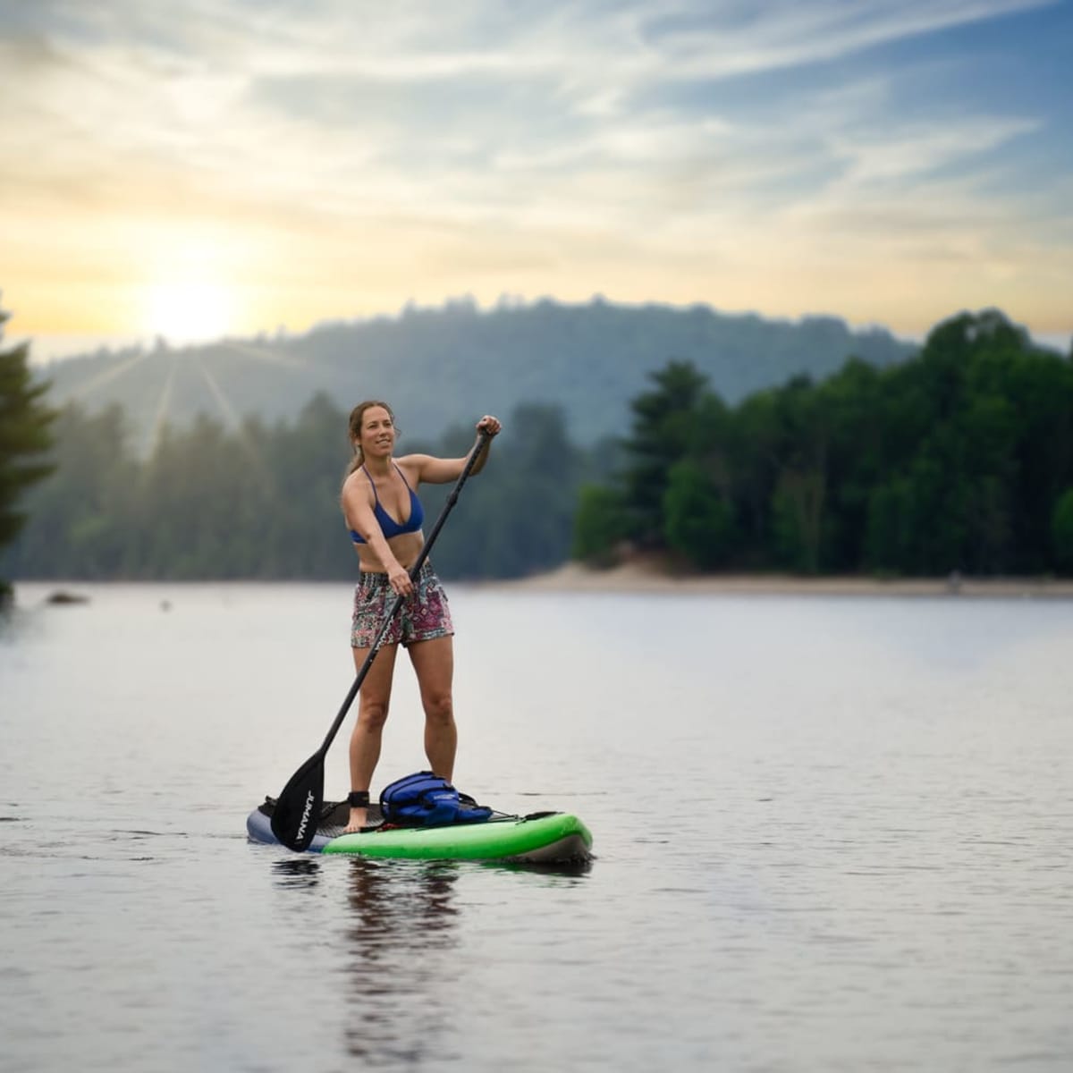 Femme en planche en pagaie sur un lac.