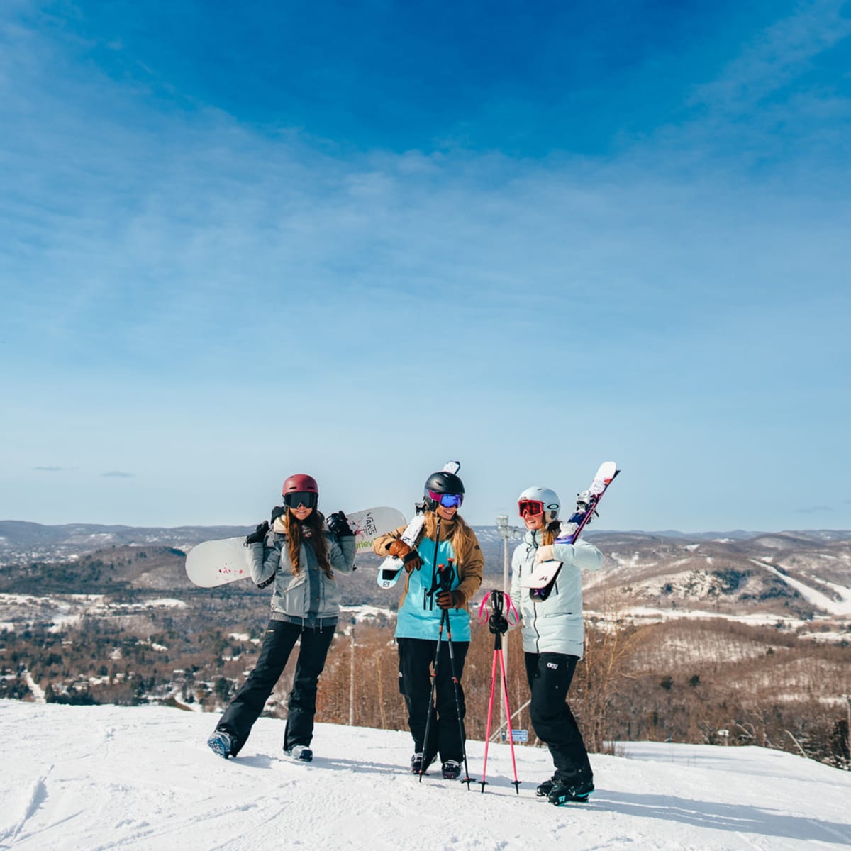 3 femmes en haut d'une montagne en ski. 