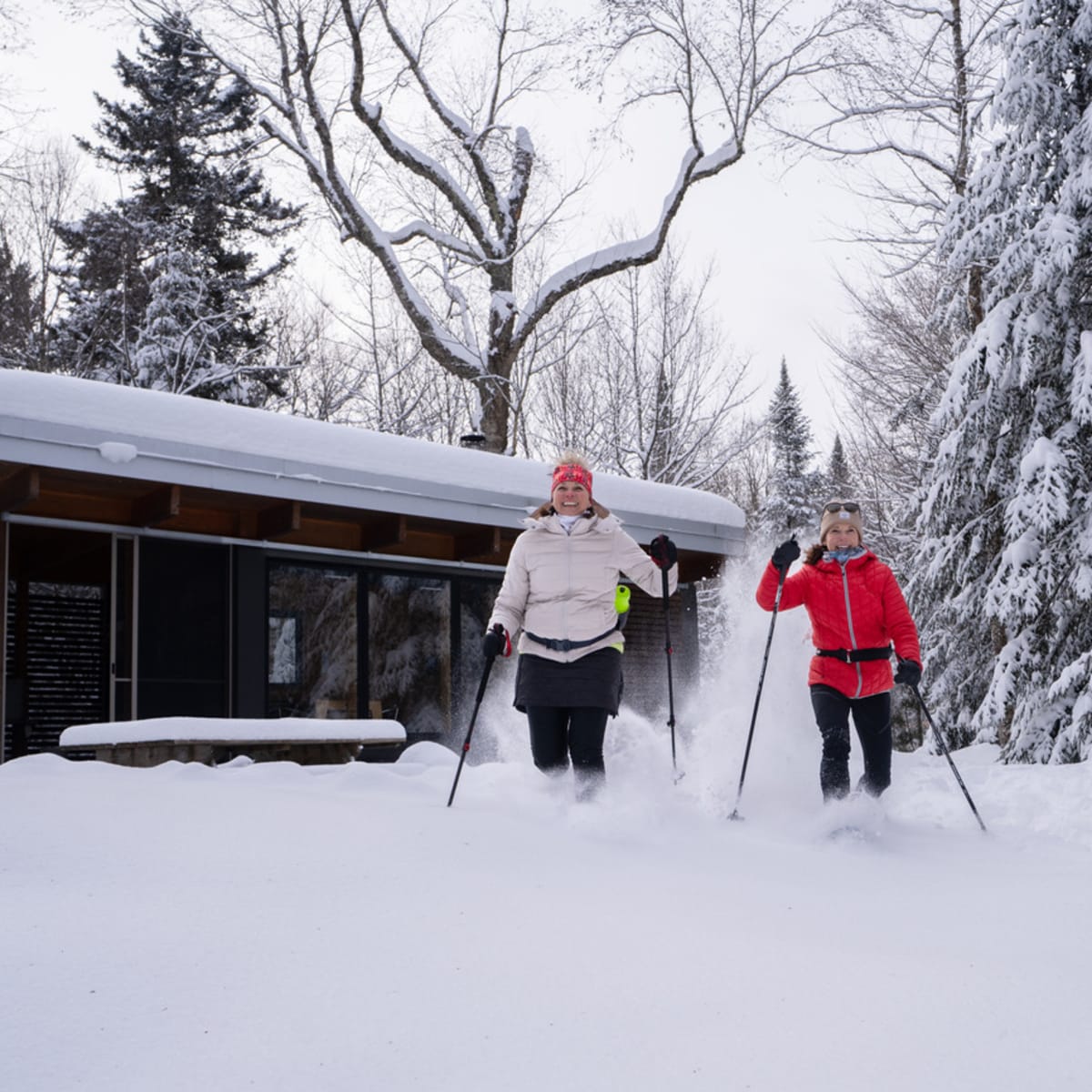 2 femmes en raquette devant un chalet.