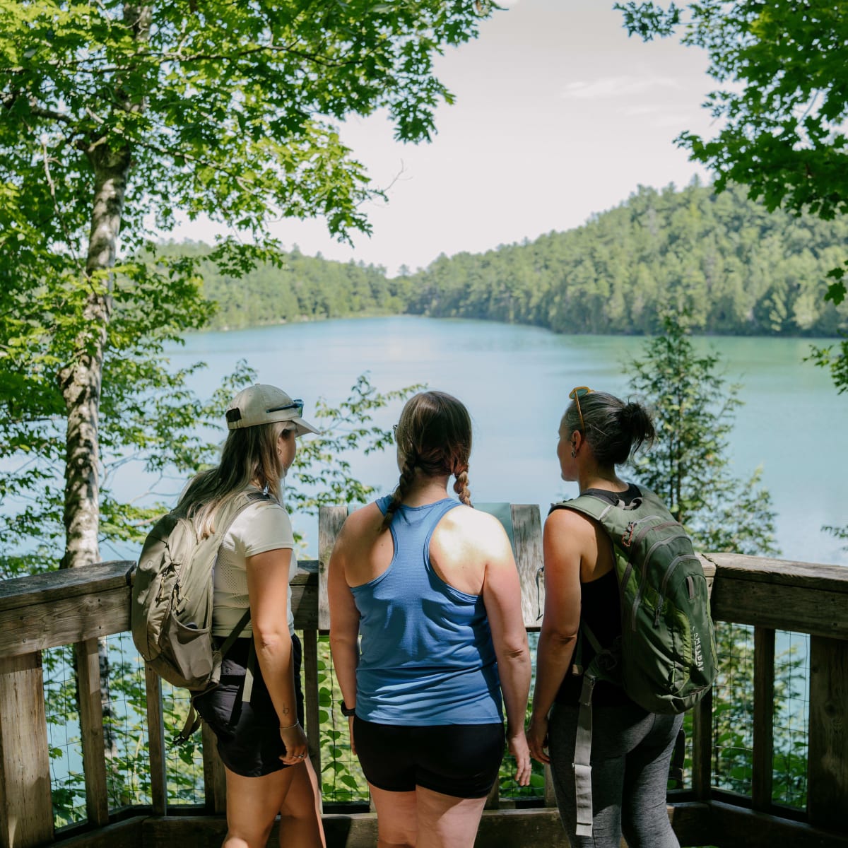 3 randonneuses devant un lac au Parc de la Gatineau. 