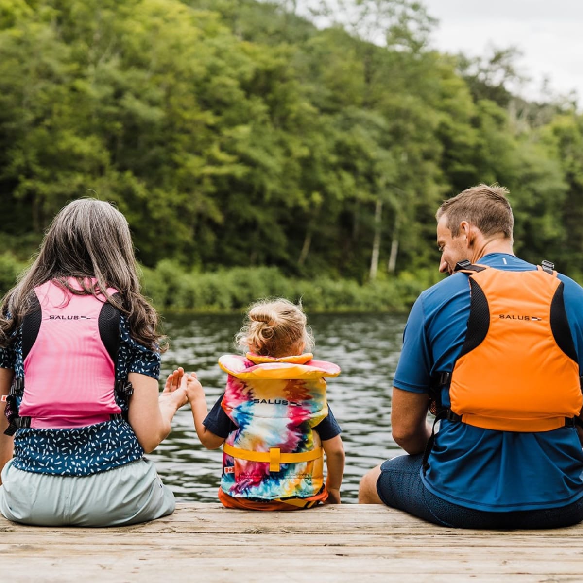 Famille assise sur un quai en été.