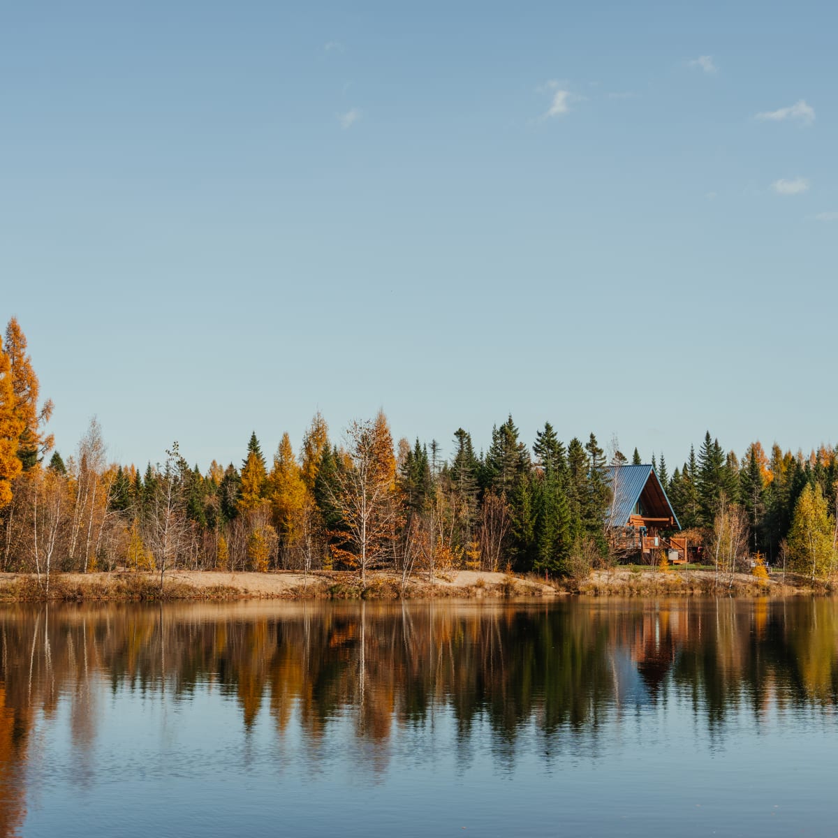 Chalet au bord d'un lac en automne Au Chalet en bois rond.