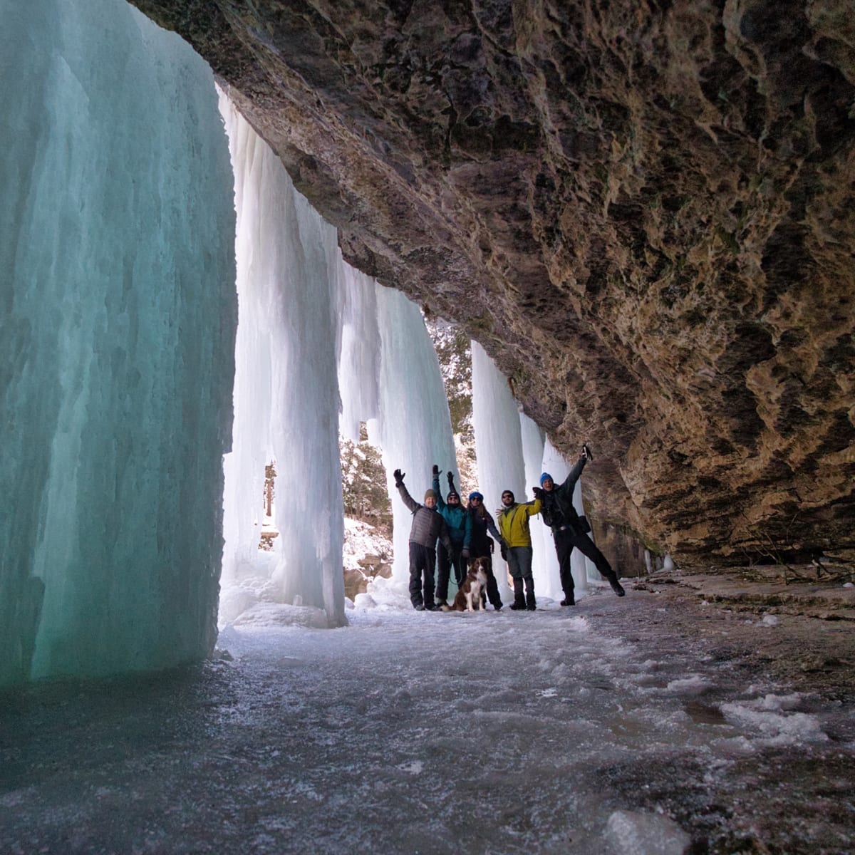Groupe de randonneurs sous une chute gelée.