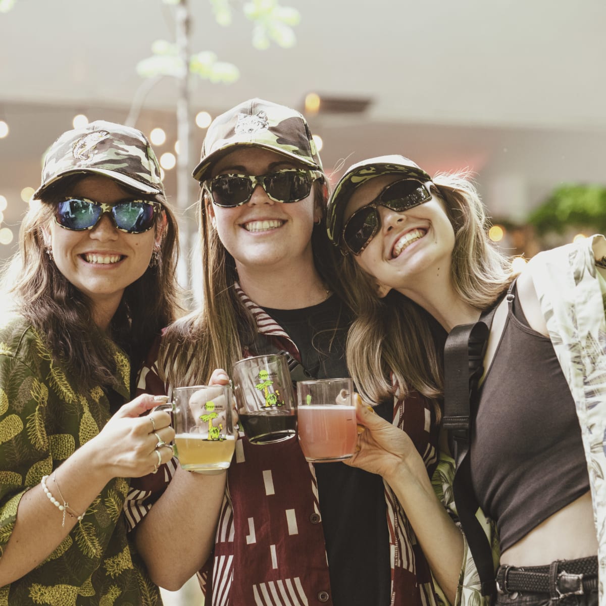 Trois jeunes femmes souriantes, bières à la main, au Festibière de Sherbrooke. 