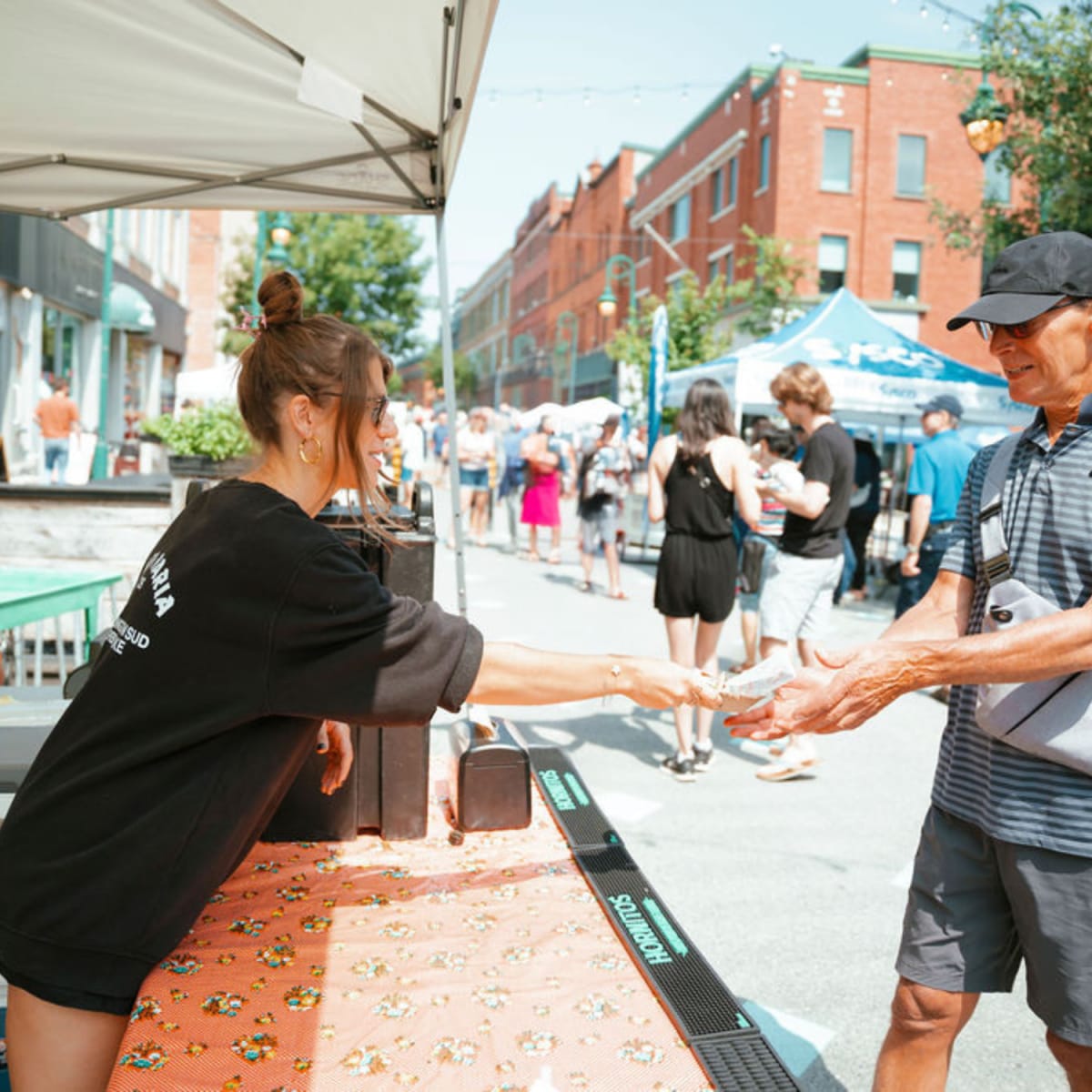 At the Bouffe ton Centro event, an exhibitor serves a dish to a visitor.