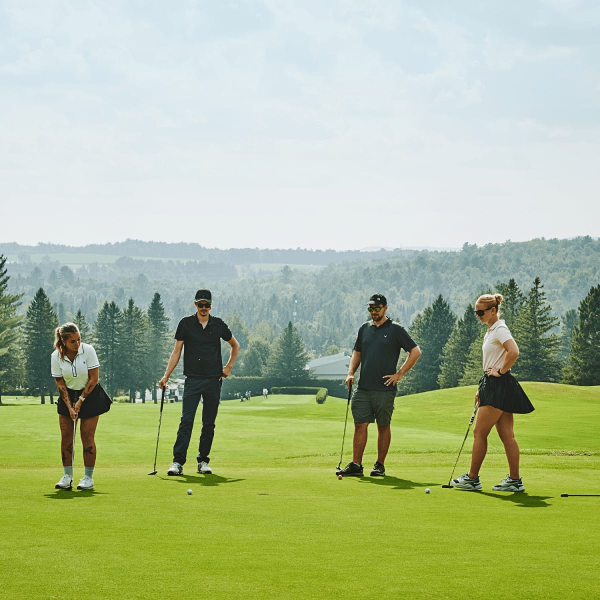 Four people on a green at the Milby Golf Club.