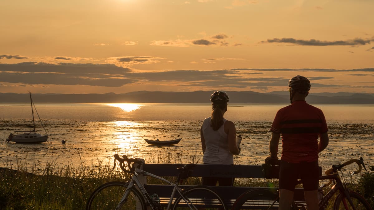 Couple de cyclistes en pause au coucher du soleil - Kamouraska