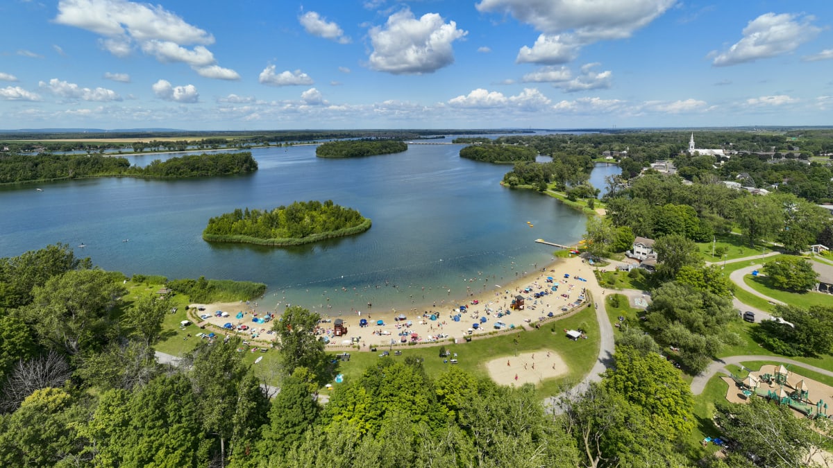 Vue aérienne d'une plage qui borde des eaux bleutées