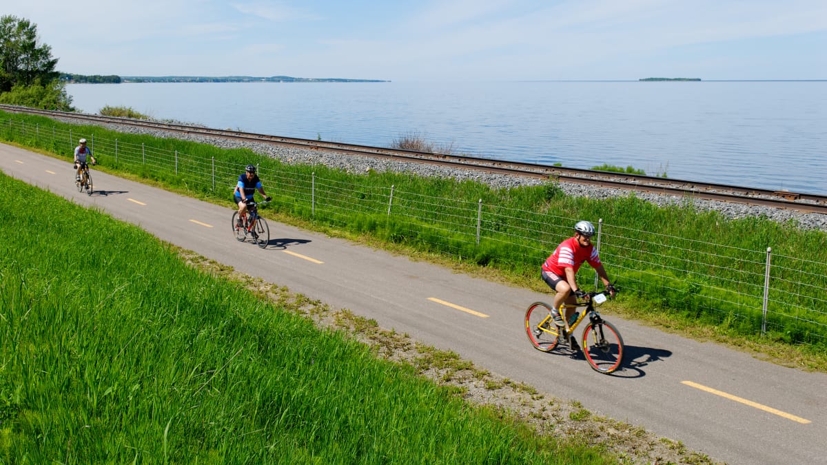 Trois personnes sur une piste cyclable au bord de l'eau