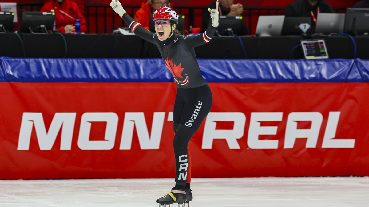 Patineuse de vitesse les bras en l'air qui semble célébrer.
