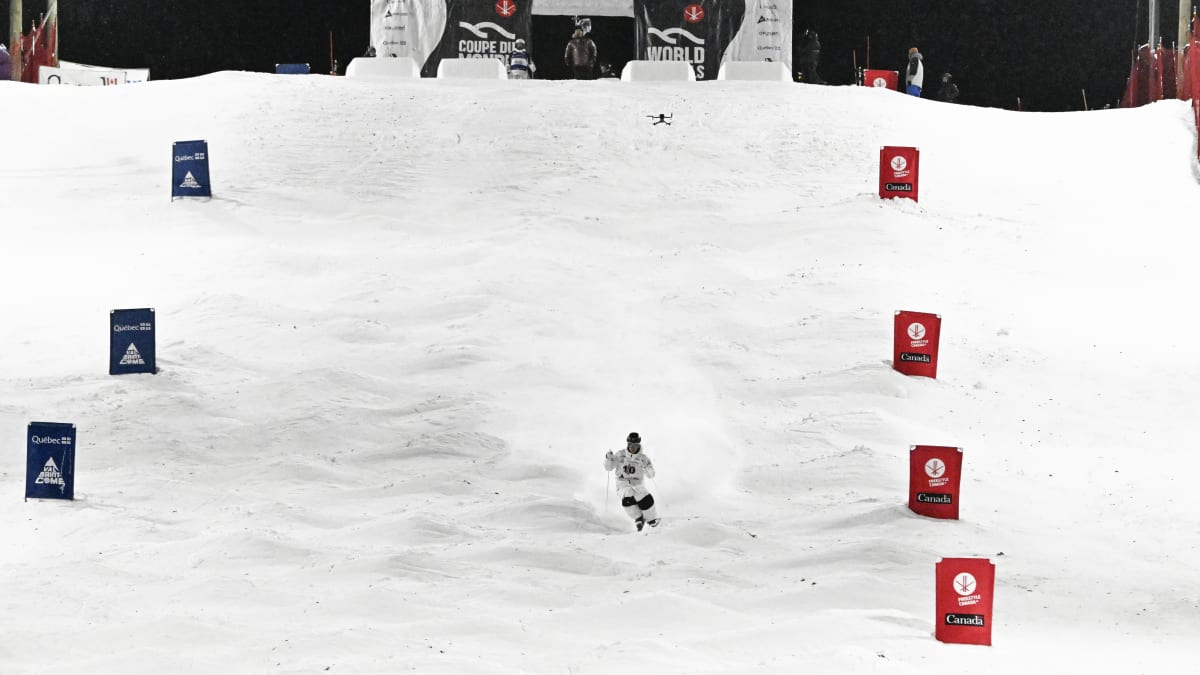 Skieur acrobatique sur une piste de bosse.