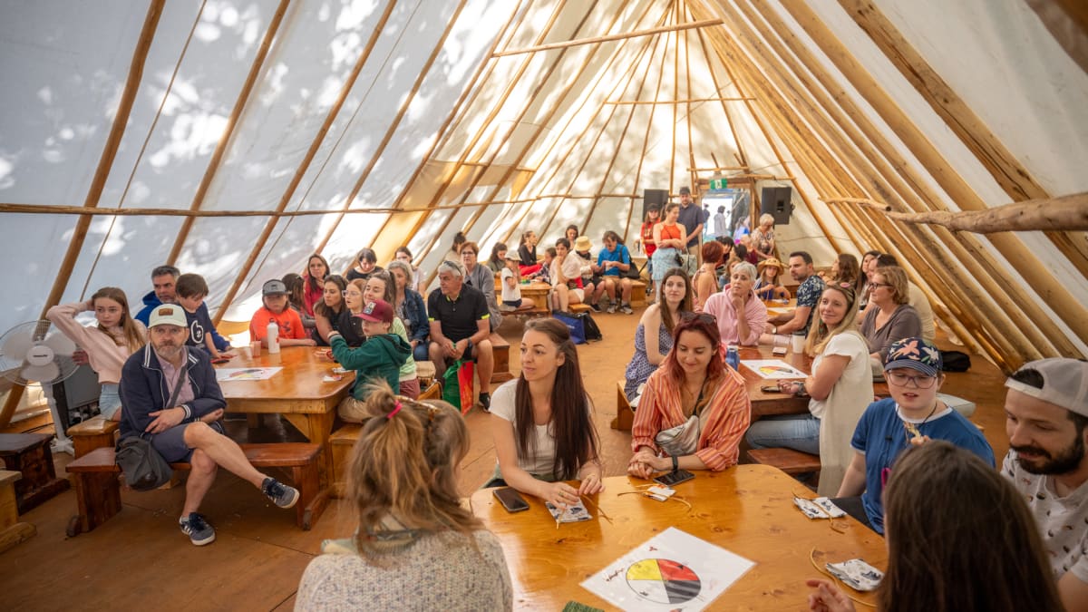 Personnes à l'intérieur d'un tipi au festival KWE