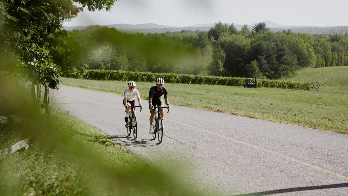 Two people on bicycles on a paved road.