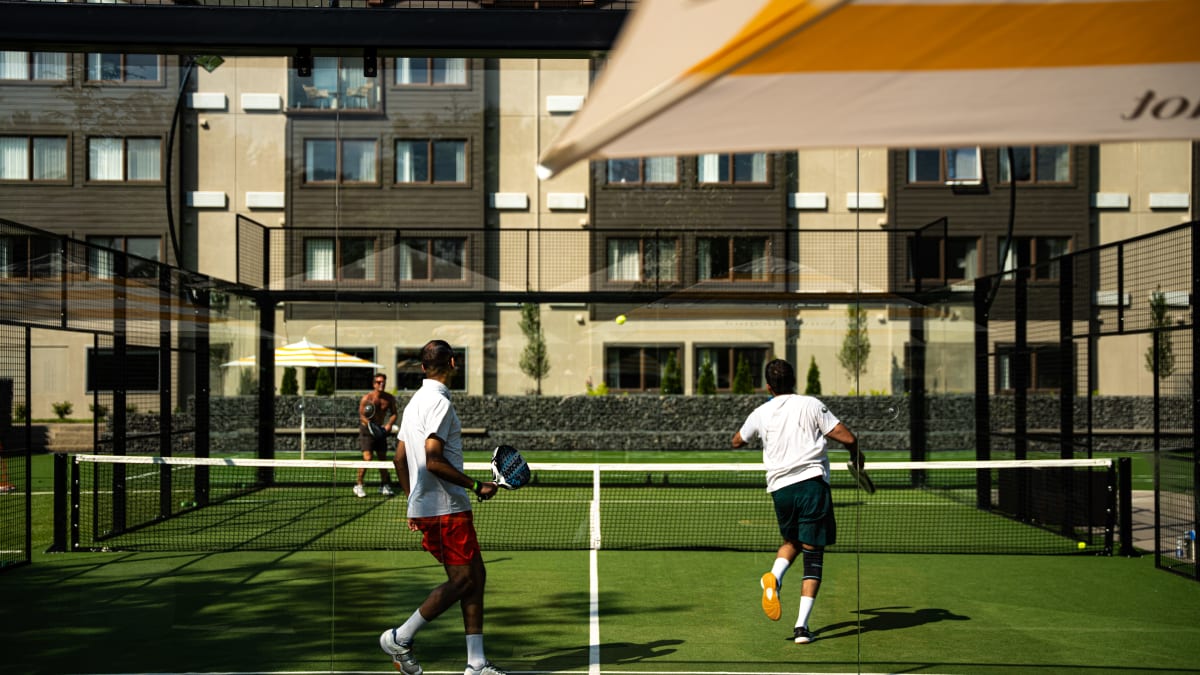 Joueurs de padel sur un terrain extérieur au Manoir Saint-Sauveur.