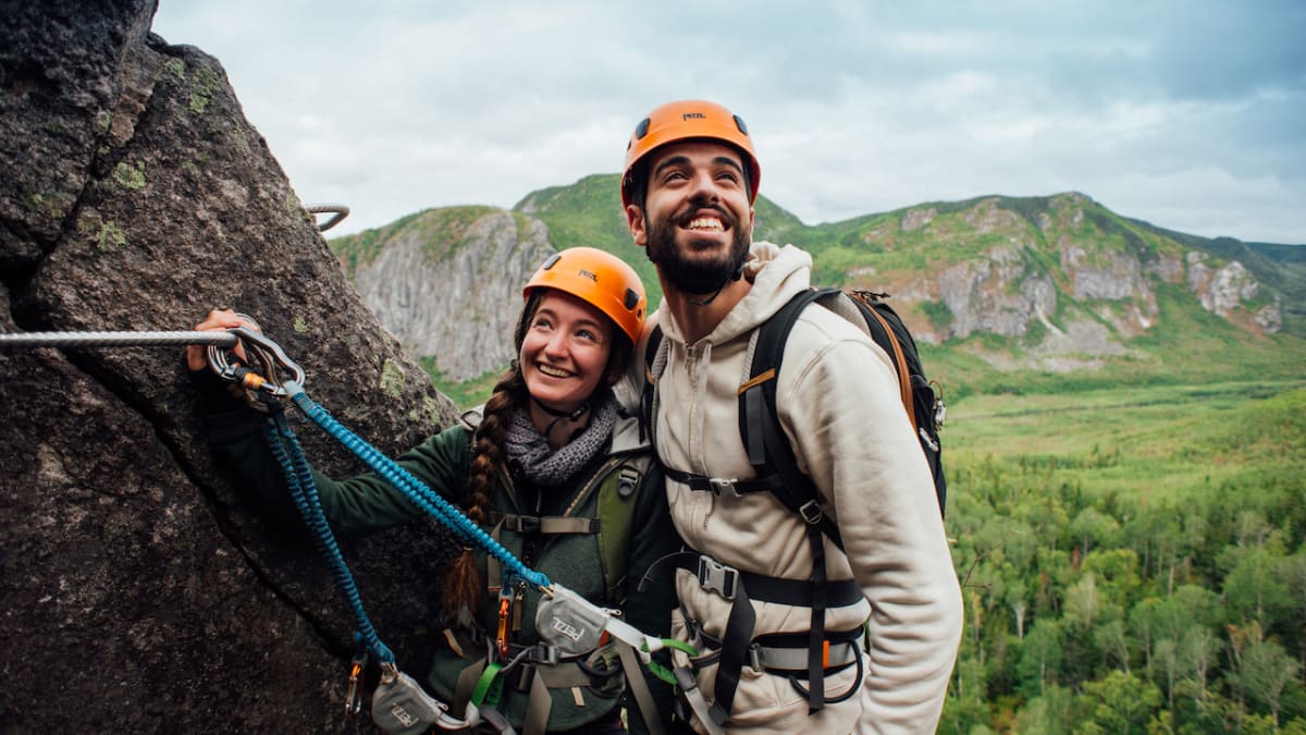 Happy couple on a cliff on a via ferrata trail.