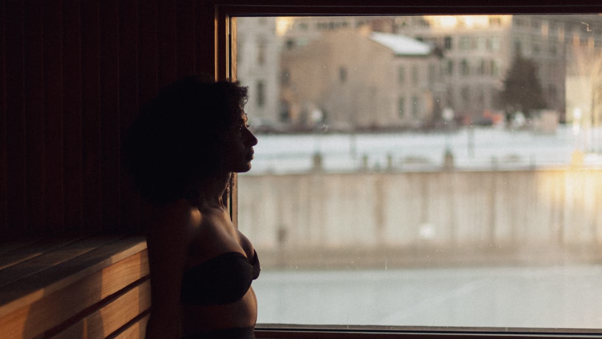 Woman in the sauna looking out over the Old Port of Montreal.