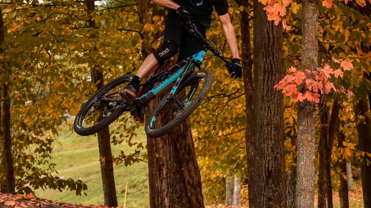 Mountain biker making a jump in a fall setting.