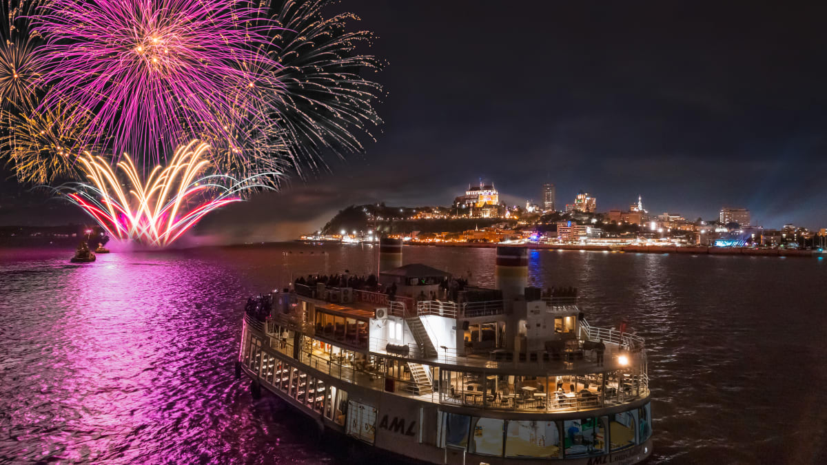 Feux d’artifice dans le ciel à Québec et bateau de croisière AML.