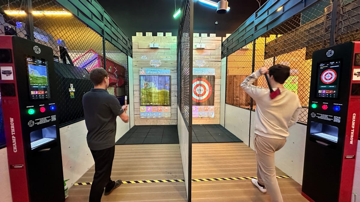 Two men taking part in an axe-throwing activity.