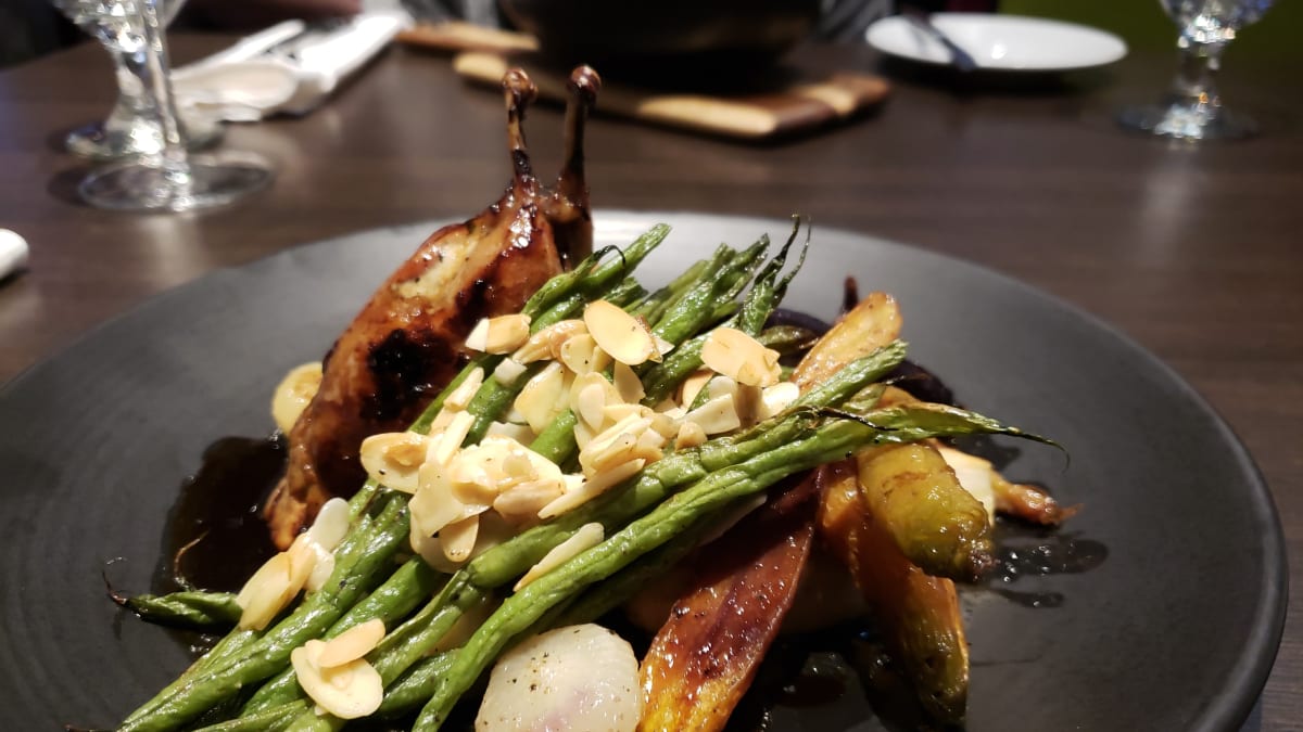 A plate of poultry with asparagus, carrots and almonds.