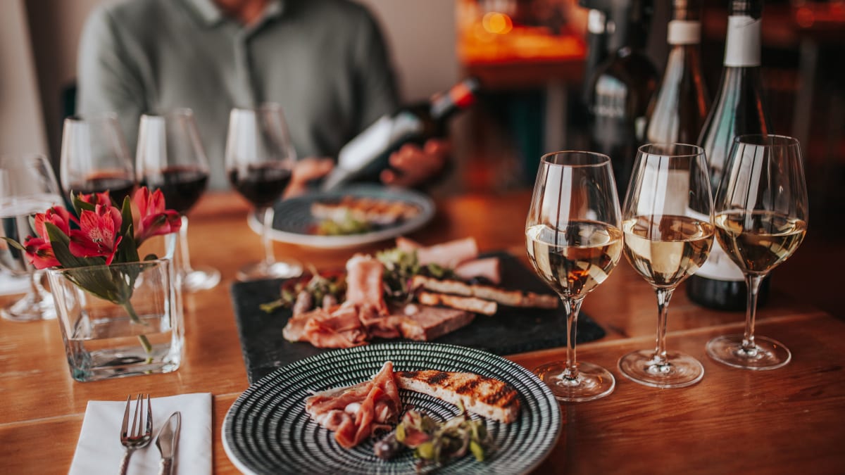 Tasting experience with multiple glasses of wine and a plate of food.