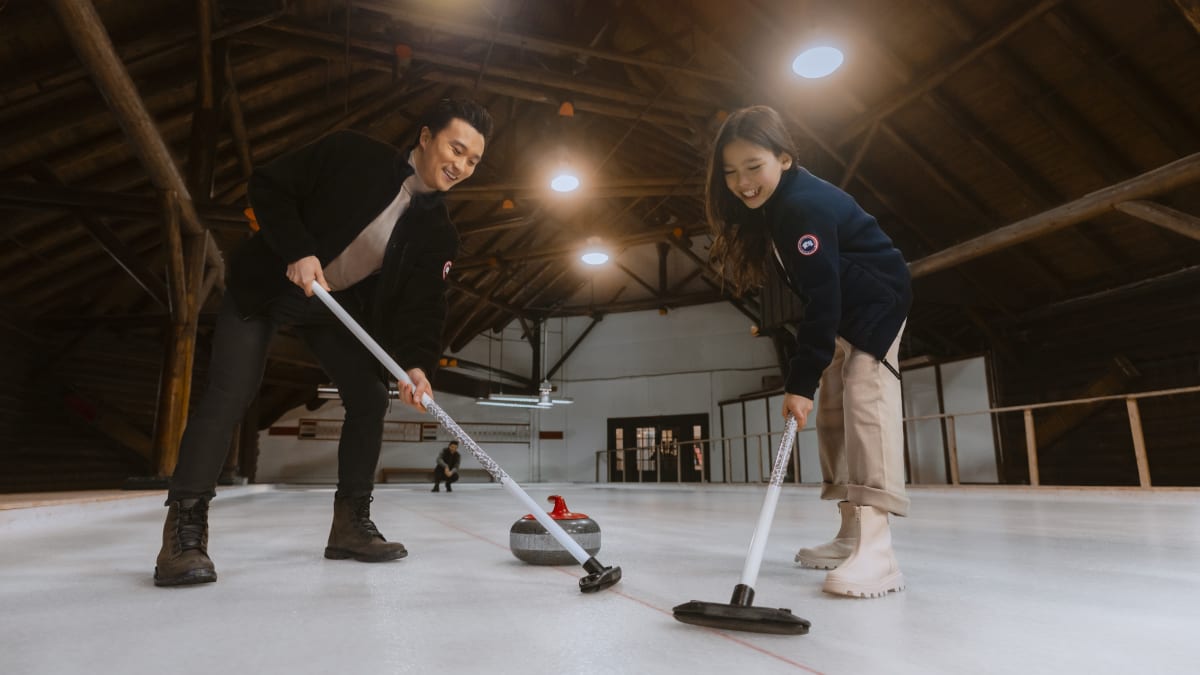 Deux personnes en train de jouer au curling.