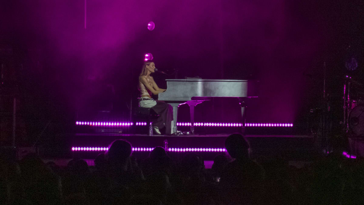 Charlotte Cardin au piano sur scène en soirée.
