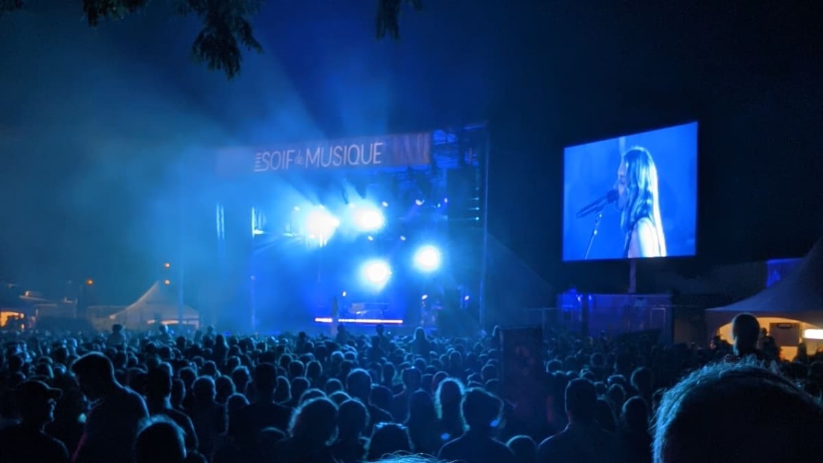 Foule en soirée sous une lumière bleutée.