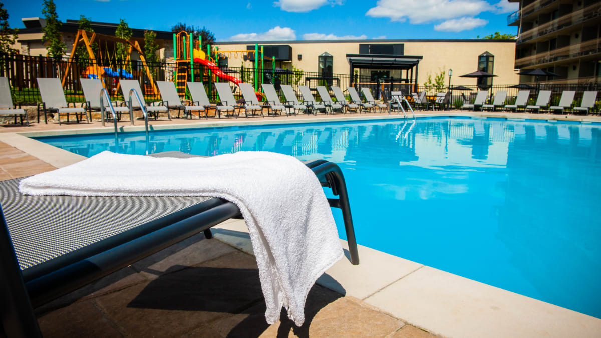 La piscine extérieure entourée de chaises longues à l'Hôtel Castel.