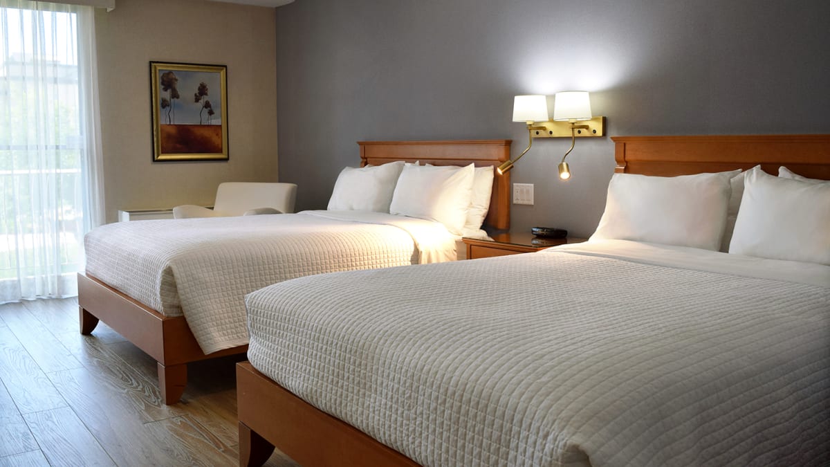 Chambre avec deux grands lits à l'Hôtel Castel.