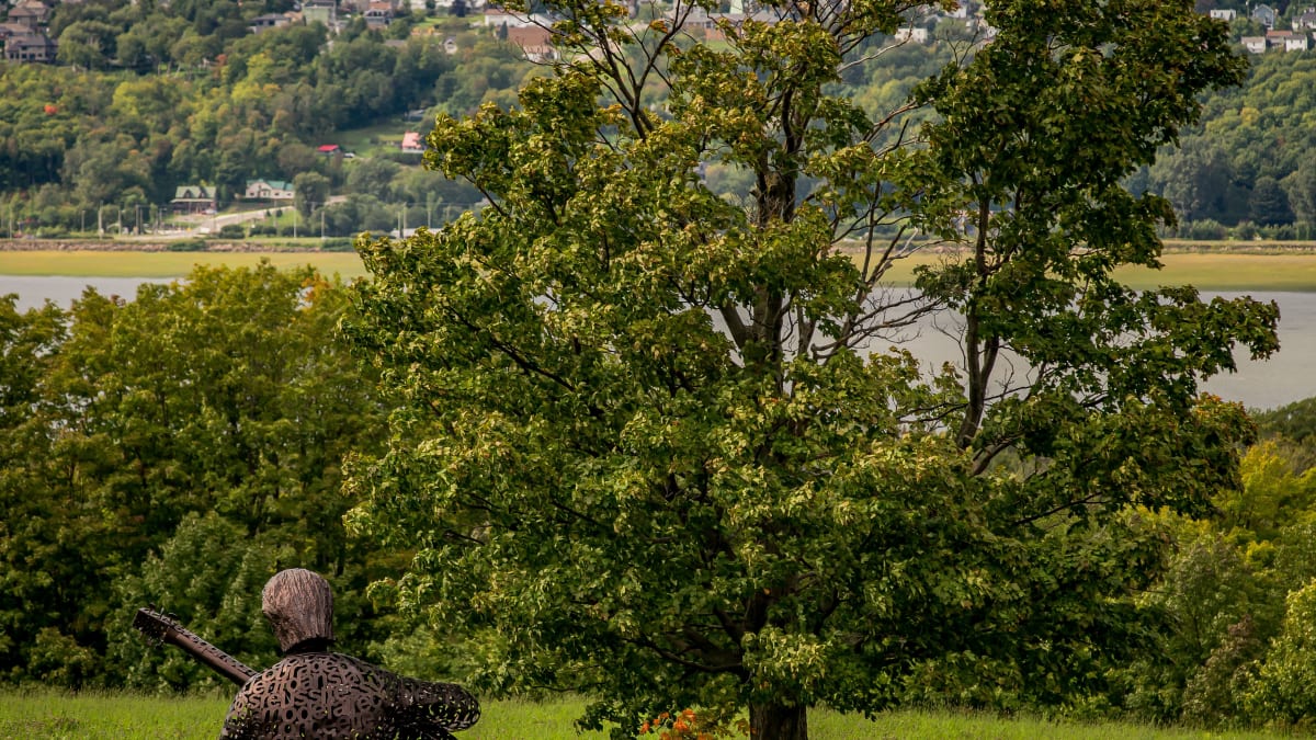 Abstract sculpture depicting Felix Leclerc and the coastal scenery of ile d'Orleans.