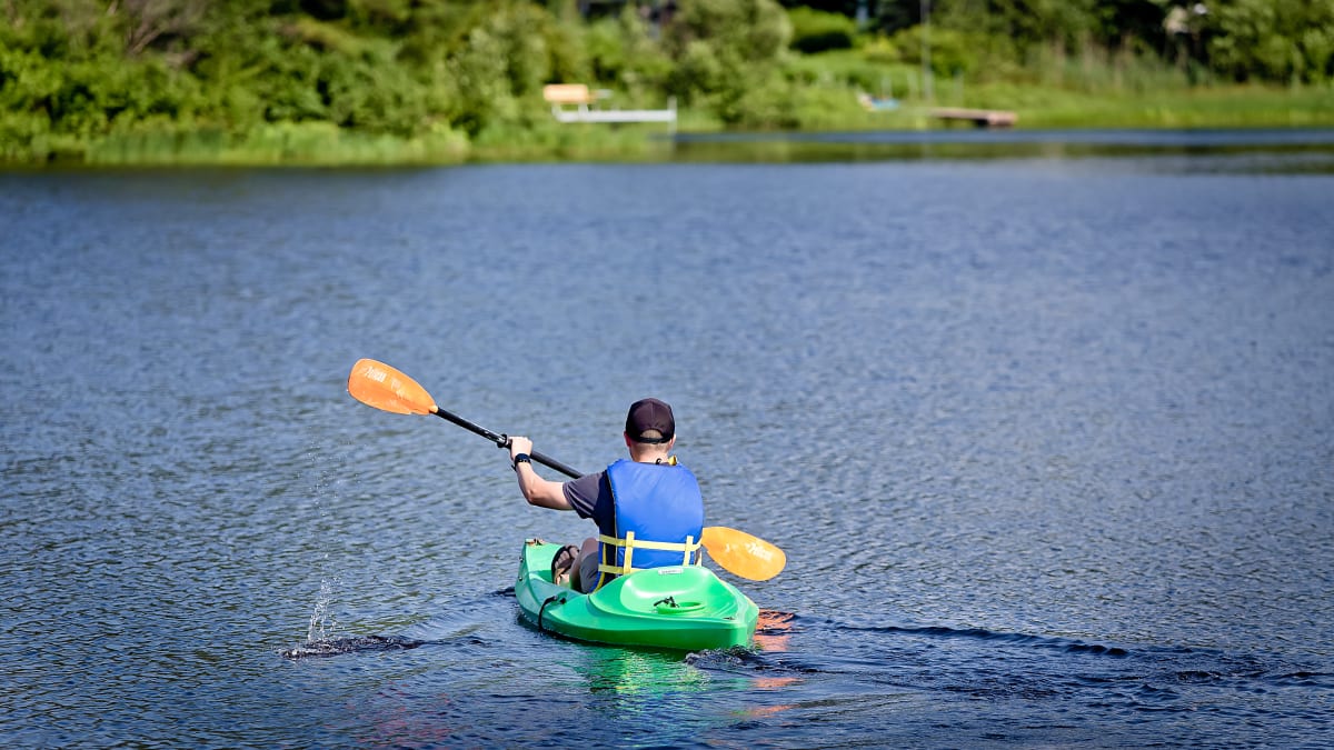 Homme de dos à la caméra en kayak sur le lac privé.