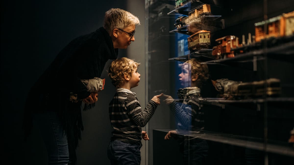 Jeune garçon et grand-parent regardant l'exposition de train miniatures