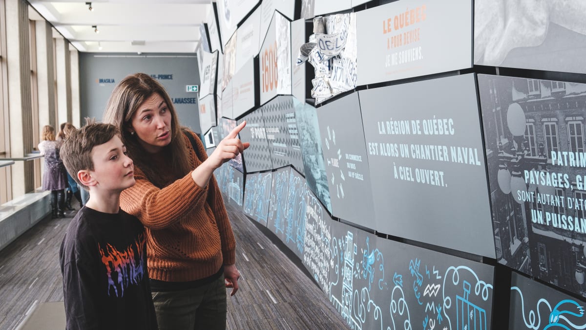 Une femme et son fils en train d'observer une exposition.
