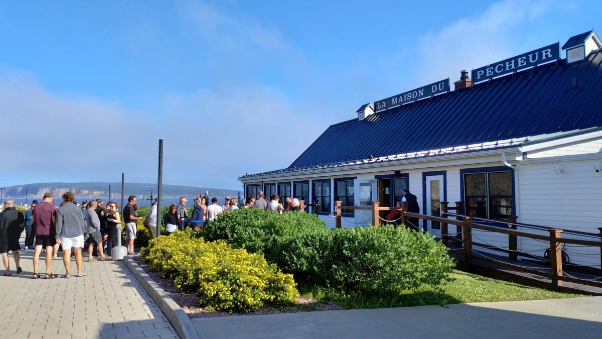 File d’attente à l’extérieur d’un restaurant appelé La Maison du Pêcheur.