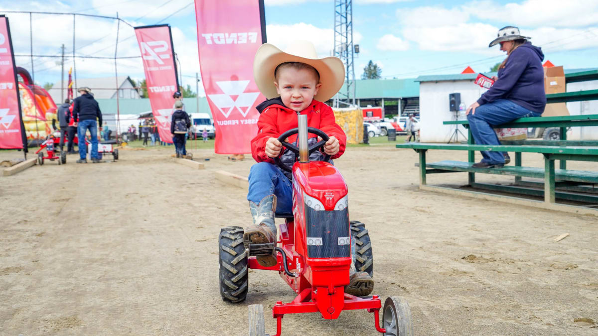 Young boy on a miniature tractor at the Ayer's Cliff Rodeo.