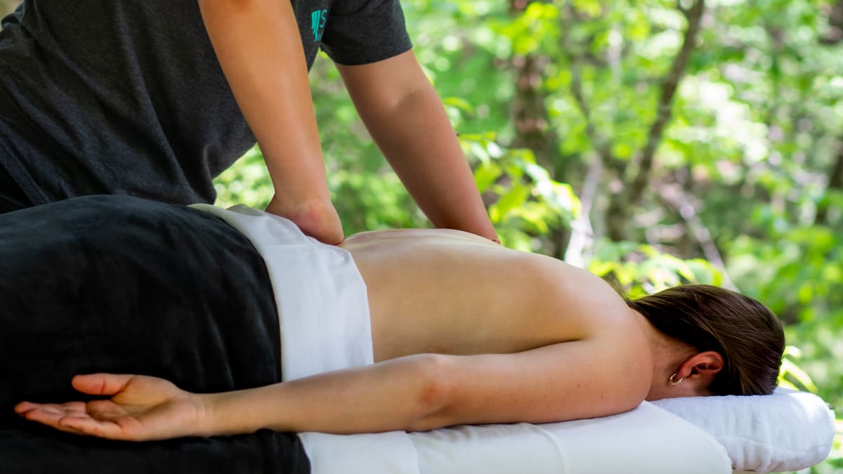 Femme en train de se faire masser le dos sur une table de massage.